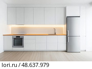 Modern trendy kitchen design with white cabinets. Subway tile backsplash, marble countertop. No brands or labels. Neutral contemporary design. Simply furniture with utensils, crockery, refrigerator. Стоковое AI-изображение, AI-художник Марина Демидюк / Фотобанк Лори