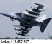 A fighter jet with a red and white tail is flying through the sky. Стоковое AI-изображение, AI-художник Ярославский Максим / Фотобанк Лори