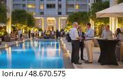 Businessmen discussing near pool during evening cocktail party. Стоковое AI-видео, аниматор Юрий Поздников / Фотобанк Лори