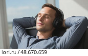 Businessman listening to music and relaxing in office chair. Стоковое AI-видео, аниматор Юрий Поздников / Фотобанк Лори