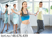 Couple in comfortable sports clothes learns boogie woogie dancing during individual lesson. Стоковое фото, фотограф Яков Филимонов / Фотобанк Лори