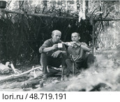 Двое мужчин на привале в лесу у самодельного шалашa. Стоковое фото, фотограф Retro / Фотобанк Лори