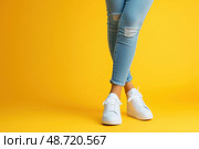 Женские ноги в джинсах и кроссовках. Стоковое AI-изображение, AI-художник Александр Жуков / Фотобанк Лори