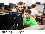 Female teacher consulting tween boy studying in computer class. Стоковое фото, фотограф Яков Филимонов / Фотобанк Лори