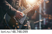 A close-up shot of a musicians hands playing an electric guitar on stage during a performance. The guitarist is wearing a black leather jacket and the stage lights are creating a bright glow. Стоковое AI-изображение, AI-художник Данила Большаков / Фотобанк Лори