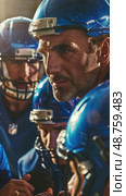 A football coach in a blue helmet gives instructions to his players before a game, close-up shot of coachs focused expression. Стоковое AI-изображение, AI-художник Данила Большаков / Фотобанк Лори