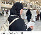 A female pilgrim with a prayer in her hands makes the traditional procession between Safa and Marwa in the Sacred Mosque of Al-Haram. Стоковое фото, фотограф Луиза Налимова / Фотобанк Лори