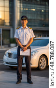 Chauffeur holding sign waiting for client in front of modern building. Стоковое AI-изображение, AI-художник Юрий Поздников / Фотобанк Лори