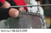 A master sharpens a chainsaw chain before work. Стоковое видео, видеограф Igor Skripachev / Фотобанк Лори