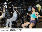 Young woman performing chest press on machine at gym. Стоковое фото, фотограф Яков Филимонов / Фотобанк Лори
