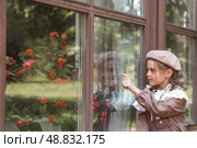 Vintage women's accessories and retro-style clothing. A small, beautiful girl with bows in her hair, in a beige dress and a beret outdoors. Стоковое фото, фотограф Photojuli / Фотобанк Лори