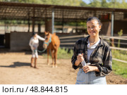 Young woman while cleaning horse paddock. Стоковое фото, фотограф Яков Филимонов / Фотобанк Лори