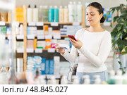 Asian woman scans ointment package. Стоковое фото, фотограф Яков Филимонов / Фотобанк Лори