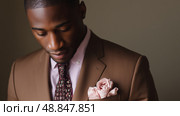 Stylish man in tailored suit with floral pocket square posed against neutral background. Стоковое AI-изображение, AI-художник Сергей Толмачёв / Фотобанк Лори