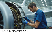 A close-up of a worker inspecting a jet engine in an aerospace facility, the intricate machinery illuminated by cool white lights. Стоковое AI-видео, аниматор Sergey Grishin / Фотобанк Лори