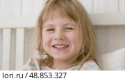 4 years girl joking, sticking tongue out with silly expression. Child making face. Funny foolishness portrait of little kid doing crazy comical gesture among a white wall. Closeup face. Low contrast. Стоковое видео, видеограф Марина Демидюк / Фотобанк Лори