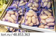 Свежий картофель, упакованный в мешки, продается в продуктовом магазине. Стоковое фото, фотограф FotograFF / Фотобанк Лори