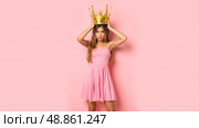 Young woman in pink dress placing large gold crown on head, unimpressed face, sarcastic mood, funny pose, royalty concept, satire theme, modern queen, humorous fashion, playful attitude. Стоковое AI-изображение, AI-художник Павел Муравьев / Фотобанк Лори
