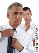 Businessman fixing his tie. Стоковое фото, агентство Ingram Publishing / Фотобанк Лори