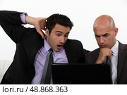 Two shocked office workers holding laptop. Стоковое фото, агентство Ingram Publishing / Фотобанк Лори