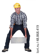 Man struggling to carry building block. Стоковое фото, агентство Ingram Publishing / Фотобанк Лори