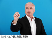 Businessman writing on a board. Стоковое фото, агентство Ingram Publishing / Фотобанк Лори