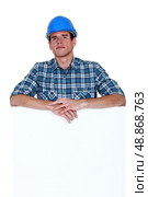Skeptical workman with a blank board. Стоковое фото, агентство Ingram Publishing / Фотобанк Лори