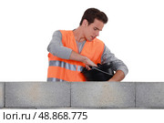 Mason stood by wall with bucket. Стоковое фото, агентство Ingram Publishing / Фотобанк Лори