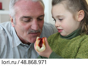Girl feeding her grandfather bread and jam. Стоковое фото, агентство Ingram Publishing / Фотобанк Лори