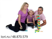 Parents playing with daughter on the floor. Стоковое фото, агентство Ingram Publishing / Фотобанк Лори