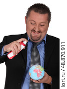 Businessman spraying a globe. Стоковое фото, агентство Ingram Publishing / Фотобанк Лори