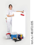 Painter posing with her supplies next to a blank sign. Стоковое фото, агентство Ingram Publishing / Фотобанк Лори