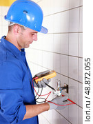 Plumber checking wiring with a voltmeter. Стоковое фото, агентство Ingram Publishing / Фотобанк Лори