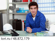 young man wearing a blue jumpsuite at office. Стоковое фото, агентство Ingram Publishing / Фотобанк Лори