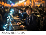 Amidst focused crowd of gamers under the glow of warm lights, solitary smiling participant engagingly competes in an eSports tournament, showcasing the liveliness of digital sports at night. Стоковое AI-изображение, AI-художник Данила Большаков / Фотобанк Лори