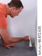 Man laying linoleum. Стоковое фото, агентство Ingram Publishing / Фотобанк Лори