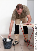 Man gluing paper. Стоковое фото, агентство Ingram Publishing / Фотобанк Лори