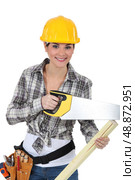 cute female carpenter using handsaw. Стоковое фото, агентство Ingram Publishing / Фотобанк Лори