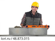 Stonemason using a bubble level. Стоковое фото, агентство Ingram Publishing / Фотобанк Лори