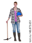 Woman construction worker standing with a pickaxe. Стоковое фото, агентство Ingram Publishing / Фотобанк Лори