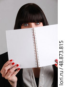 Woman hiding behind notebook. Стоковое фото, агентство Ingram Publishing / Фотобанк Лори