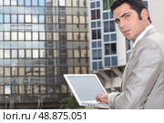 Man using his laptop outside an office block. Стоковое фото, агентство Ingram Publishing / Фотобанк Лори