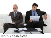 Two determined businessmen sat waiting for presentation. Стоковое фото, агентство Ingram Publishing / Фотобанк Лори