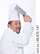 Chef in uniform wielding a cleaver. Стоковое фото, агентство Ingram Publishing / Фотобанк Лори