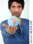 Man holding the world in the palm of his hand. Стоковое фото, агентство Ingram Publishing / Фотобанк Лори