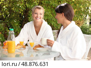 Two young women having breakfast in the garden. Стоковое фото, агентство Ingram Publishing / Фотобанк Лори