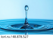 Close-up of a single water droplet captured mid-splash. Clear ripple effect on blue liquid surface. Minimalist style. Clean, pure, and refreshing concept. Studio lighting. Space for text. Banner. Стоковое AI-изображение, AI-художник Евгений Демидюк / Фотобанк Лори