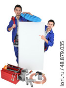 plumber with tools pointing at board. Стоковое фото, агентство Ingram Publishing / Фотобанк Лори