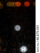 Raindrops Cascade Down the Glass Pane, Distorting the City Lights Beyond the Window. Стоковое фото, фотограф Aleksandr Golubev / Фотобанк Лори