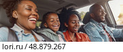 A family of four enjoys a sunny day, laughing together while driving in a car. Стоковое AI-изображение, AI-художник Данила Большаков / Фотобанк Лори